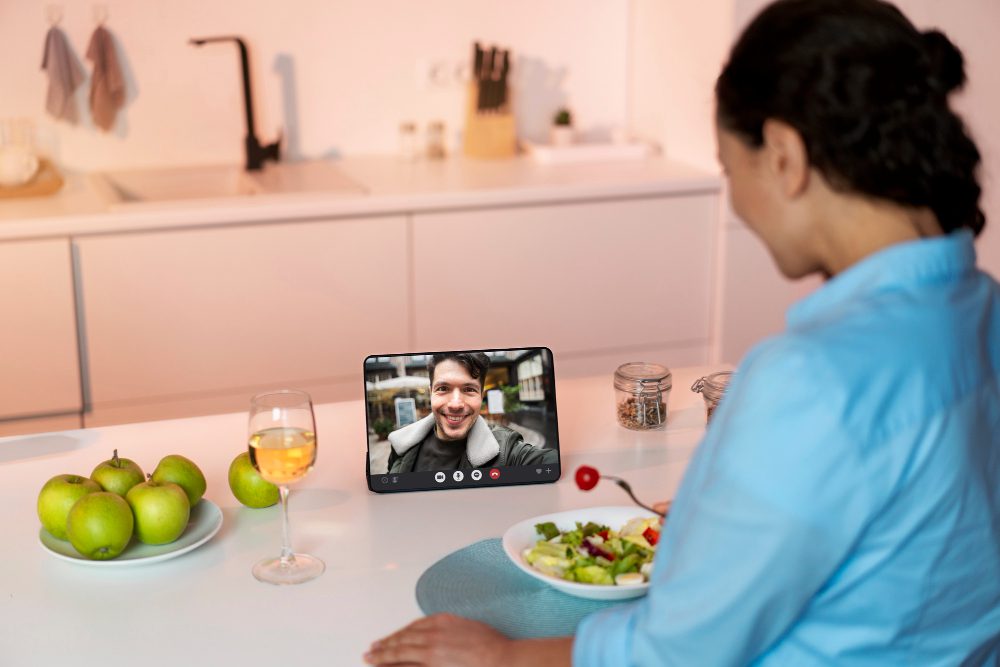 Person having a video call at a kitchen table with food and drink